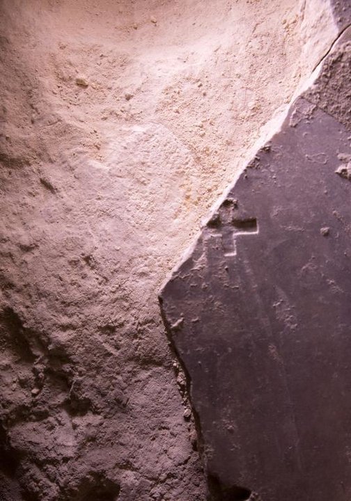 Esta losa de mármol rota, con una cruz cristiana, podría datar de la época de las Cruzadas. Debajo, la roca caliza donde supuestamente, yació Cristo.Foto: Oded Balilty, AP for National Geographic 