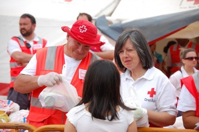 Un grupo de voluntarios de Cruz Roja reparte alimentos. 