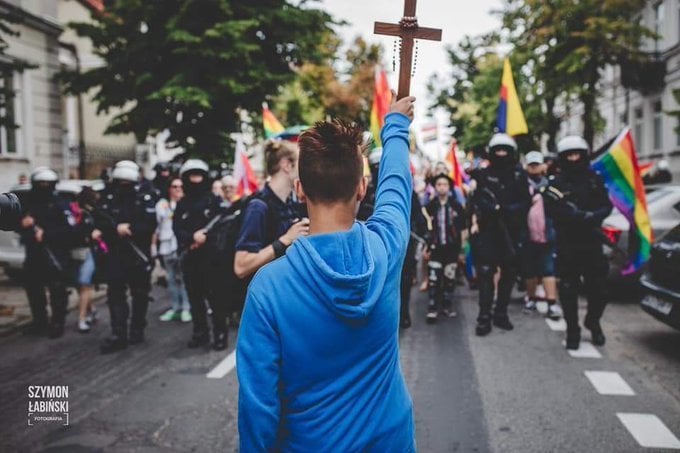 Un joven muestra un crucifijo a manifestantes LGTB.